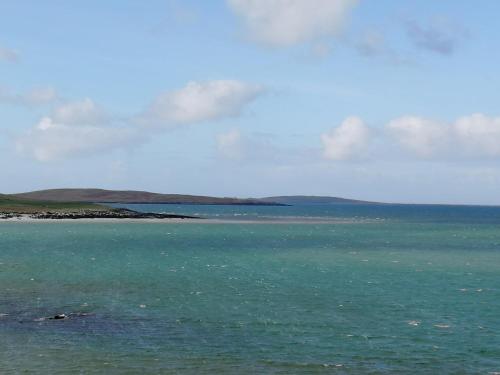 a large body of water with mountains in the background at The Fisherman's Snug self catering North Uist in Paible
