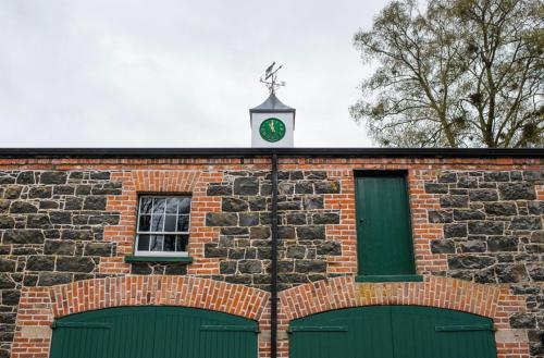 a brick building with a clock on top of it at Courtyard Cottages at Ballyscullion Park in Derry Londonderry