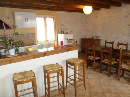 cocina con encimera y taburetes de madera en gite l'opale en Lailly-en-Val