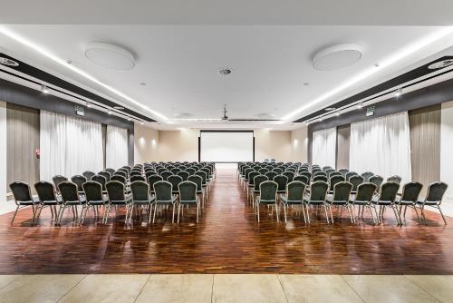 an empty room with chairs and a screen at Artis Loft Hotel in Radziejowice