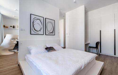 a white bedroom with a large white bed at Apartmánový dům U Tomana in Brno