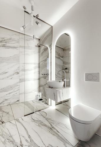 a white bathroom with a sink and a mirror at Apartmánový dům U Tomana in Brno