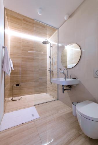 a bathroom with a shower and a toilet and a sink at Apartmánový dům U Tomana in Brno