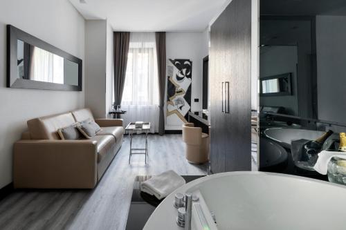 a living room with a couch and a bath tub at LHP Hotel Napoleon in Milan