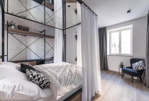 a bedroom with a canopy bed and a window at Apartmánový dům U Tomana in Brno