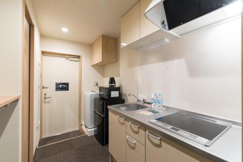 eine kleine Küche mit Spüle und Kühlschrank in der Unterkunft Stay SAKURA Kyoto Shijo Karasuma in Kyoto