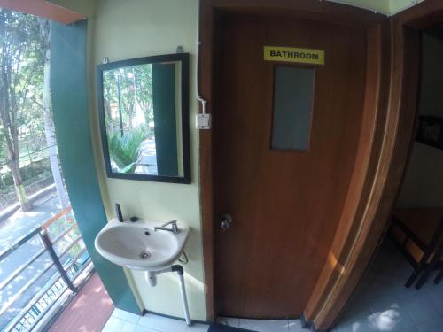 a bathroom with a sink and a door with a mirror at Dhika Adventure in Probolinggo