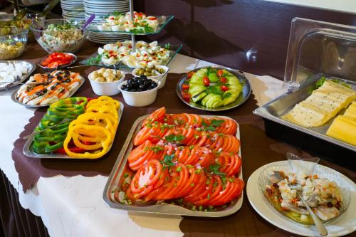 a table with many plates of food on it at Aparthotel Bellamonte in Zakopane