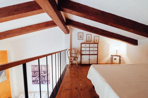サン・カシャーノ・イン・ヴァル・ディ・ペーザにあるAgriturismo Il Pintelloの屋根裏のベッドルーム(ベッド1台、椅子付)