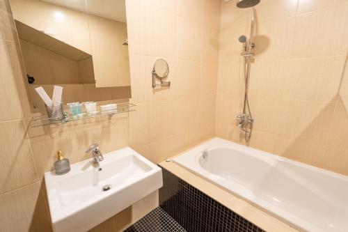 a bathroom with a sink and a bath tub at Mini-hotel People in Odesa