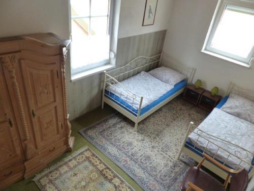 a bedroom with a bed and a dresser and two windows at Ferienwohnung Baierl in Nördlingen