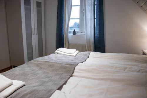 a white bed in a room with a window at Stora Herrestad B&B in Ystad