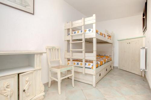 a bedroom with two bunk beds and a chair at Residence La Marmorata in Santa Teresa Gallura