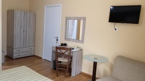 a room with a bed and a table and a mirror at Ambrosia Suites in Athens