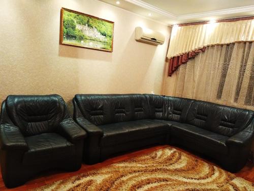 a black leather couch in a living room at Tiraspol Apartments in Tiraspol