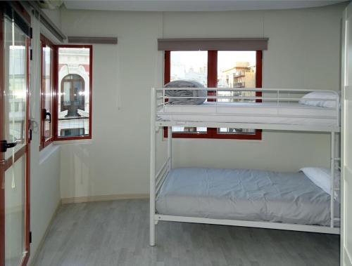 瓦倫西亞的住宿－ÁTICO EN EL CENTRO DE VALENCIA Pta 12 VT-45939-T，带窗户的客房内的两张双层床