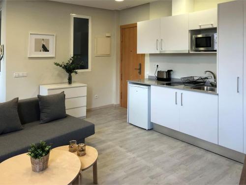 een woonkamer met een bank en een keuken bij ÁTICO EN EL CENTRO DE VALENCIA Pta 12 VT-45939-T in Valencia