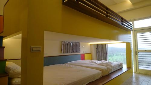 a bedroom with two beds and a large window at Happy Cape 玩皮城堡 in Huxi