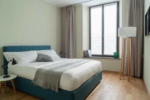 a bedroom with a blue bed and a window at Brera Apartments Alla Scala in Milan