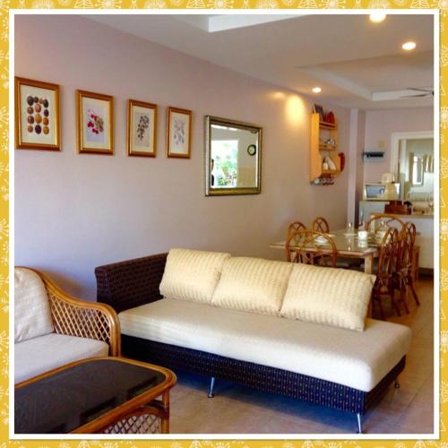 a living room with a couch and a table at ห้องชุด 2 ห้องนอน ริมหาด ณ บ้านทะเลสำราญ ชะอำ in Ban Khlong Khot