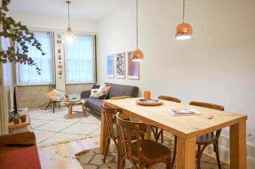 sala de estar con mesa y sofá en UNIK Porto Apartment en Oporto