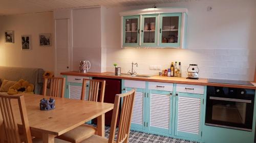 eine Küche mit blauen Schränken und einem Holztisch in der Unterkunft Ferienhaus Mauseloch in Kaub