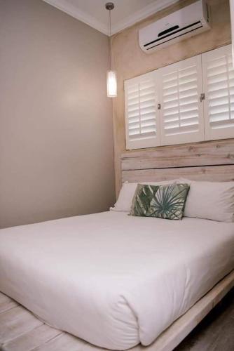 a bedroom with a large white bed with white pillows at 61 Cabanas in Durban