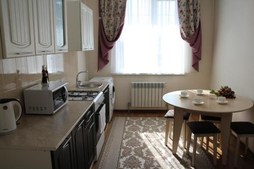 a small kitchen with a table and a microwave at Апарт отель Welcome in Taldykorgan