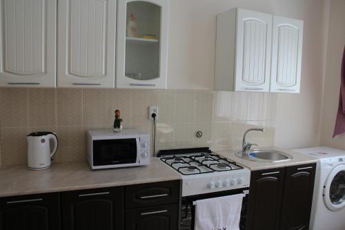 a kitchen with a stove and a microwave at Апарт отель Welcome in Taldykorgan