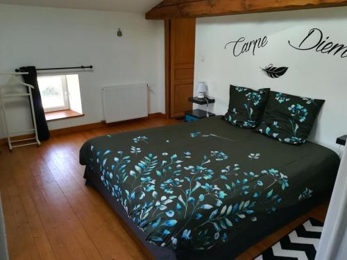 ein Schlafzimmer mit einem Bett mit einer grünen Bettdecke in der Unterkunft Les Marmottes Charentaises in Tonnay-Boutonne
