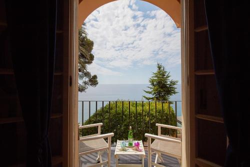 an open door to a balcony with a view of the ocean at Hotel Punta Est in Finale Ligure