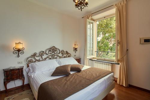 a bedroom with a large bed and a window at Hotel Punta Est in Finale Ligure