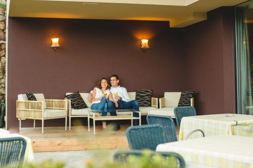 a man and woman sitting on a couch in a room at feldthurnerhof vinum-natur-relax in Feldthurns
