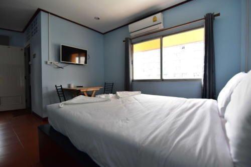 a bedroom with a large white bed and a window at amenity@22 in Bangkok