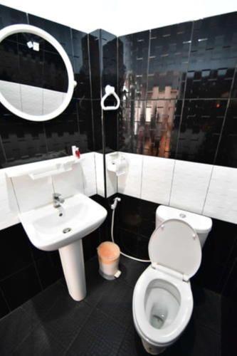 a bathroom with a toilet and a sink and a mirror at amenity@22 in Bangkok