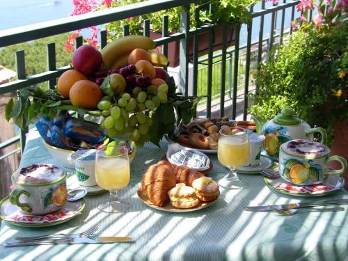 a table with a bowl of fruit and a vase of bread at Locanda Degli Agrumi in Conca dei Marini