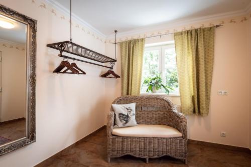 a wicker chair in a room with a mirror at Chalet Jagdhof in Sankt Johann im Pongau