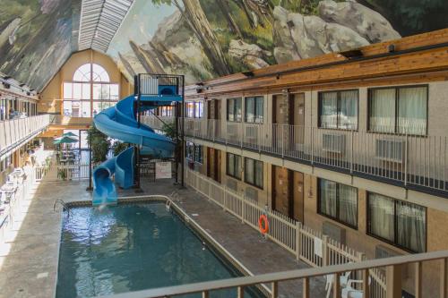 a indoor pool with a slide in a building at Days Inn by Wyndham Lethbridge in Lethbridge