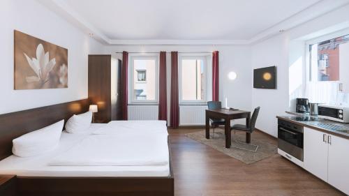 a hotel room with two beds and a desk at Aparthotel - Stadtvilla Premium in Schweinfurt