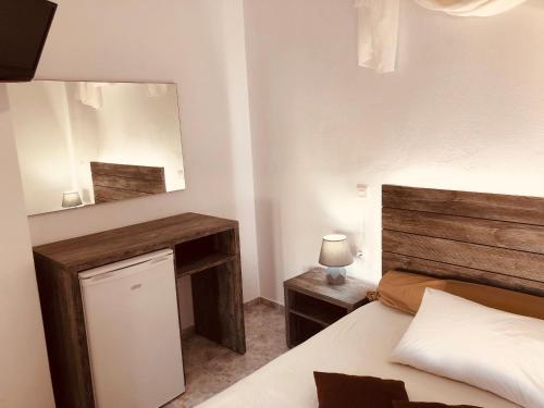 a bedroom with a bed and a mirror on the wall at Villa Livadaros in Karterados