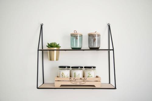 a shelf with three jars and a plant on it at thomlocation in Saint-Paul