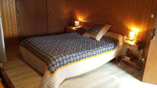 a bedroom with a bed with two night stands and two lamps at LA FERME DU NIZON in Valeilles