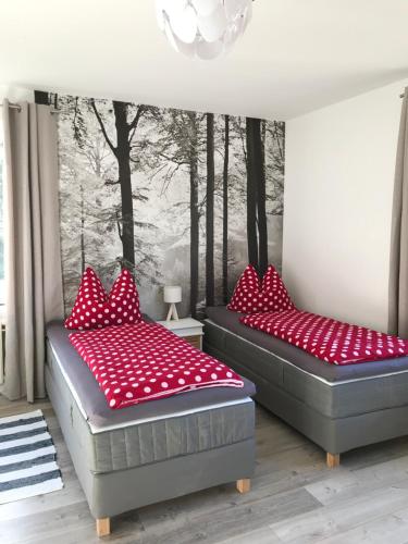 フレンスブルクにあるAppartement Moervigの赤い枕付きのベッド2台が備わる客室です。