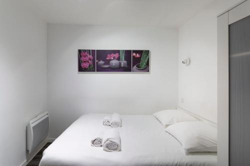 - une chambre dotée d'un lit blanc avec une photo sur le mur dans l'établissement MANDCHOU by Cocoonr, à Rennes