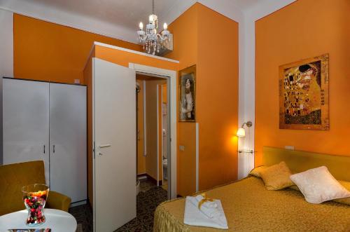 1 dormitorio con paredes de color naranja, 1 cama y 1 mesa en B&B La Mimosa, en Lucca