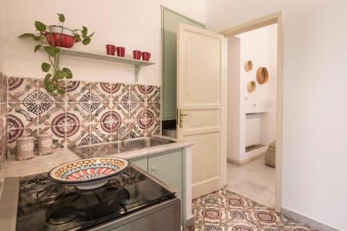 een keuken met een wastafel en een fornuis top oven bij Casa degli Affreschi a Palazzo Lungarini in Palermo