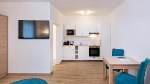 a kitchen and dining room with a table and blue chairs at Hotel - Stadtvilla Central in Schweinfurt