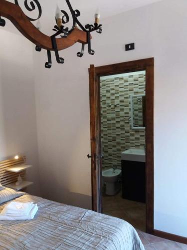 a bedroom with a bed and a bathroom with a mirror at Castello in Valguarnera Caropepe