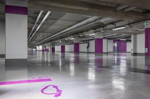 an empty parking garage with a pink number on the floor at INNSiDE by Meliá Paris Charles de Gaulle Airport in Roissy-en-France