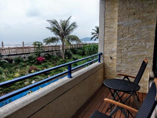 a balcony with chairs and a table and a view of the ocean at Ocean B&B in Hualien City